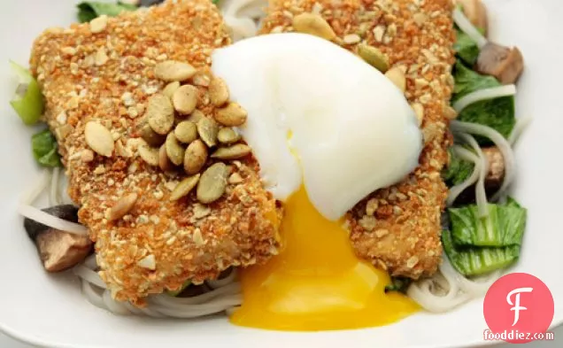 कद्दू-लेमनग्रास शोरबा, चावल नूडल्स, और पके हुए अंडे के साथ बीज-क्रस्टेड टोफू