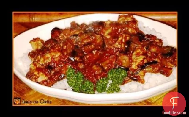 चावल पर टमाटर सॉस में सॉटेड बैंगन और पोर्क