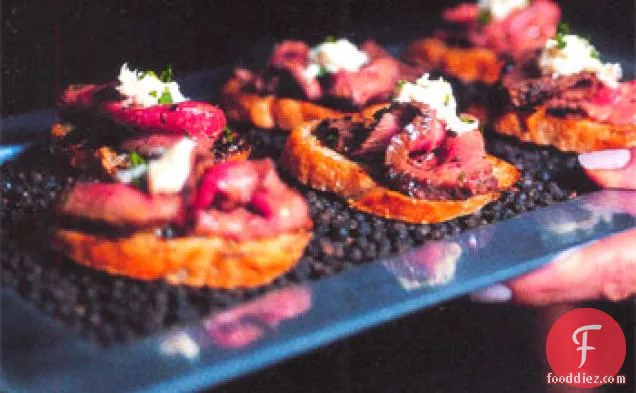 ग्रील्ड लहसुन क्रोस्टिनी पर हॉर्सरैडिश क्रीम के साथ काली मिर्च-क्रस्टेड स्टेक