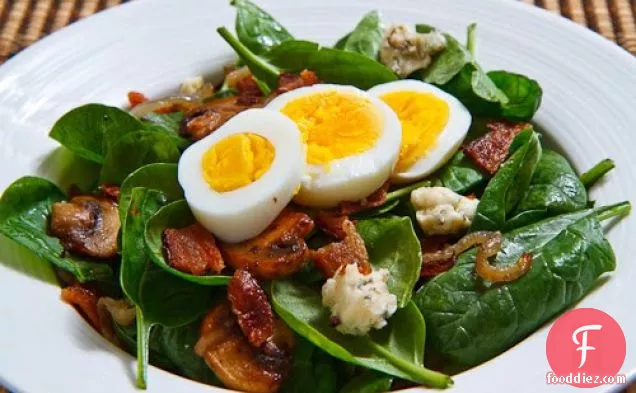 Spinach Salad with Bacon, Caramelized Onions, Mushrooms and Blue Cheese in a Bacon Pan Sauce Dressing Topped with a Hard Boiled Egg