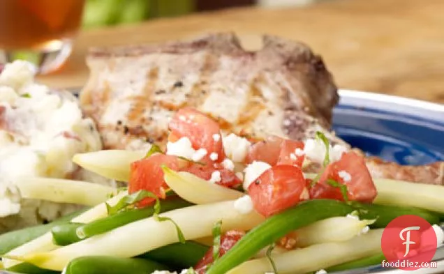 चंकी टमाटर ड्रेसिंग और फेटा चीज़ के साथ हरा और पीला बीन सलाद