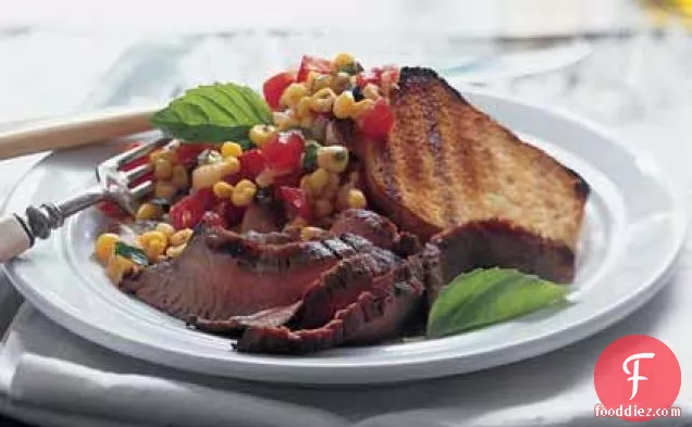 मकई-टमाटर के स्वाद और ग्रिल्ड गार्लिक ब्रेड के साथ फ्लैंक स्टेक