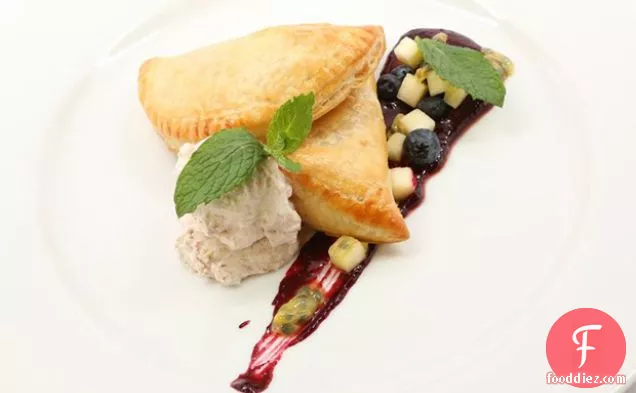 ब्लूबेरी-मिंट सॉस और नारियल क्रीम के साथ व्हाइट चॉकलेट पैशन फ्रूट टर्नओवर