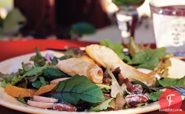 क्रैनबेरी-पोर्ट विनैग्रेट और कैंडिड पेकान के साथ मिश्रित सर्दियों के साग पर काली मिर्च-चेवरे पेस्ट्री