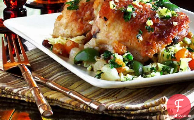 मोती प्याज, हरे जैतून, सुनहरी किशमिश और संरक्षित नींबू के साथ ब्रेज़्ड चिकन जांघ