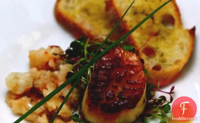 बटर पोच्ड लॉबस्टर के साथ नारंगी तारगोन विनैग्रेट के साथ माइक्रो ग्रीन्स पर कटा हुआ स्कैलप्स