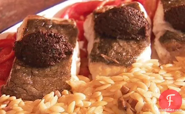 भुनी हुई लाल मिर्च पर काले जैतून के टेपेनेड के साथ ओवन-भुना हुआ हलिबूट (बलात्कार असाडो कोन टेपेनाडा नेग्रा वाई पिमिएंटोस मोरोन्स)