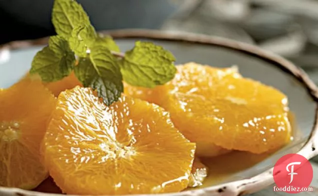 शहद और नारंगी खिलने वाले पानी के साथ नारंगी स्लाइस
