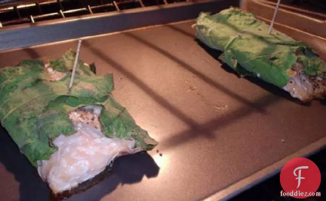 पके हुए केल के साथ अंजीर के पत्तों में लिपटे सामन